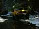 1978 Ford Bronco - A yellow 1978 Ford Bronco navigates a wet and snowy forest road.