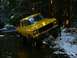 1978 Ford Bronco - A yellow 1978 Ford Bronco navigates a muddy, snowy stream in a forest setting.