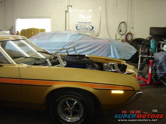 Gold 1972 Ford Ranchero with orange stripe, hood open, parked in garage