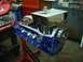 1972 Ford Ranchero - Engine block and intake assembly on a stand in a workshop. Text on a box reads "CYLINDER HEAD".