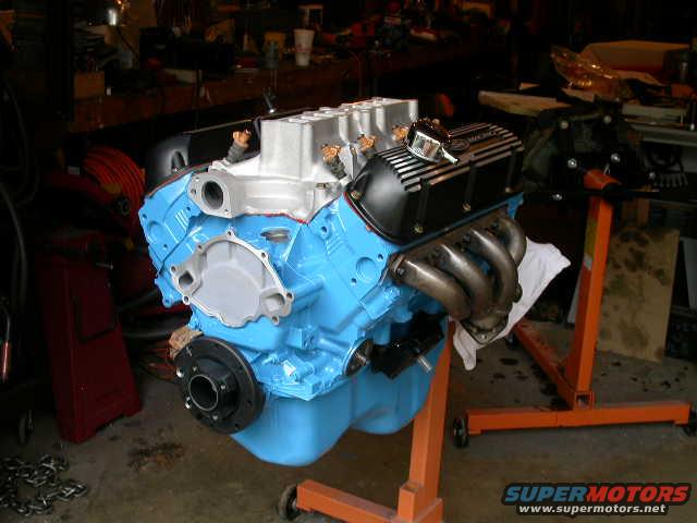 blue engine block with black valve covers on an orange engine stand
