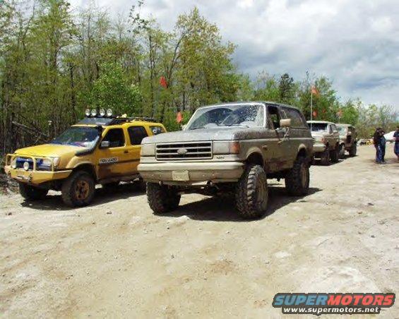 Gray 1987 Ford Bronco with large tires on a dirt road
