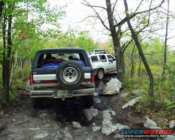 Rear view of a 1991 Ford Bronco on a rocky trail, spare tire mounted externally
