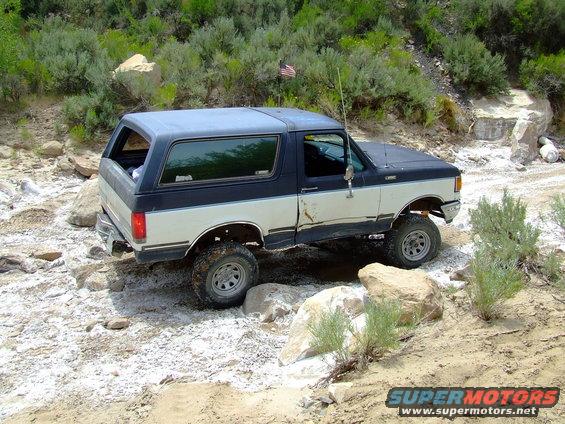 1987 Ford Bronco 3q-front view off-roading on rocky terrain