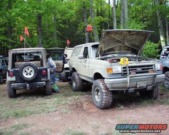 White 1991 Ford Bronco front view, hood open, parked next to a Jeep