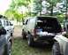 1991 Ford Bronco - This 1991 Ford Bronco is seen with its tailgate open, revealing stored items, parked alongside other off-road vehicles.