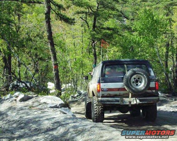 Ford Bronco with spare tire on rear, off-road tires, on a dirt path