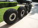 1983 Ferrari Enzo - Four off-road tires are displayed on a driveway, with two vehicles visible in the background.