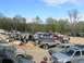 1991 Ford Bronco - A variety of off-road vehicles are gathered in a dirt lot, suggesting an event or meetup for enthusiasts.