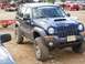 1991 Ford Bronco - A modified blue Jeep Liberty is shown with large off-road tires and a scoop on the hood.