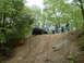 1991 Ford Bronco - A black SUV navigates a challenging dirt incline while onlookers observe the off-road action.
