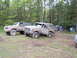 1991 Ford Bronco - Two 1991 Ford Broncos are parked at a campsite, with tents and trees visible in the background.