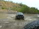 1991 Ford Bronco - A black truck navigates a muddy off-road course, with another vehicle visible in the foreground.