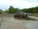 1991 Ford Bronco - A Ford Bronco navigates a challenging muddy terrain, kicking up spray as it goes.