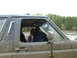 1991 Ford Bronco - A muddy 1987 Ford Bronco is seen from the side, with two occupants visible through the windows.