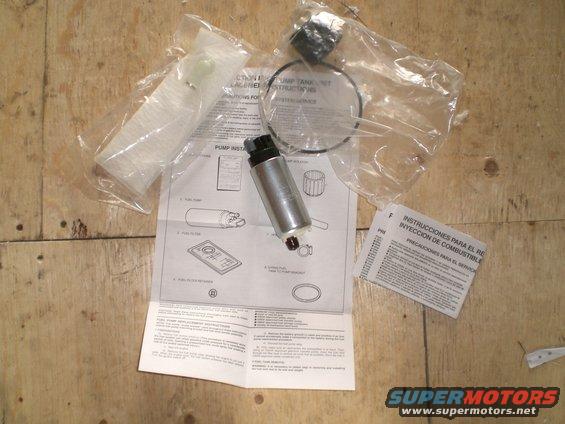 Fuel pump, filter, seal, and installation instructions laid out on a wooden surface
