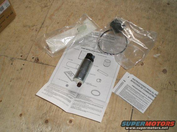 Fuel pump with installation instructions and parts laid out on a wooden surface
