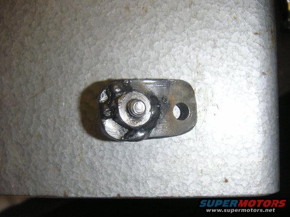 Metal bracket with a bolt and weld, on a textured surface