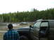 1991 Ford Bronco - Off-roading scene with two trucks navigating through a muddy terrain.