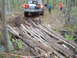 1991 Ford Bronco - A 1991 Ford Bronco navigates a challenging off-road course, using a makeshift bridge of logs to cross a muddy section of trail.