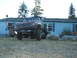 1976 GMC Sierra 2500 - A heavily modified pickup truck is shown with its front wheels elevated on large rocks.