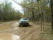 1991 Ford Bronco - Truck navigating a muddy trail in a wooded area.