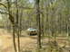 1991 Ford Bronco - A muddy 1987 Ford Bronco navigates a challenging off-road course in a wooded environment.