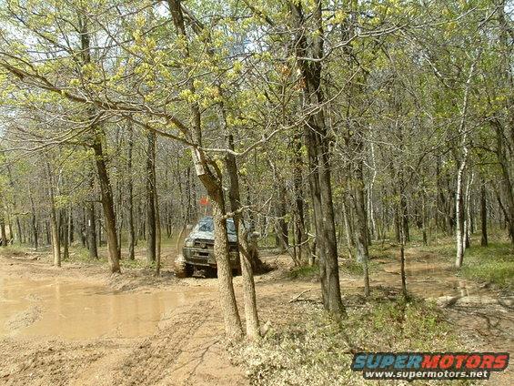 Off-road vehicle driving through mud in a forest