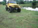 2001 Jeep Wrangler - A yellow 2001 Jeep Wrangler is parked on a grassy area next to a body of water.