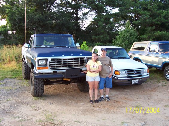 Blue and white Ford F-150 pickup truck with lifted suspension and large tires, front view