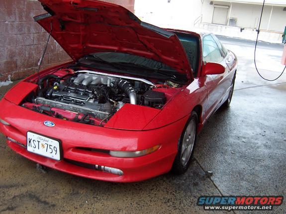 Red 1995 Ford Probe front view with hood open, engine exposed