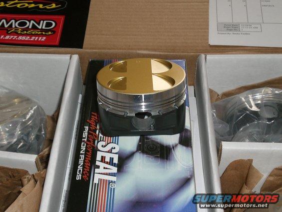 Performance pistons in boxes with packaging that says 'High Performance Piston Rings' and 'Diamond Pistons'