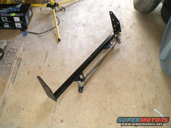 black metal suspension component with adjustable rod, on wooden floor
