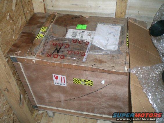 Wooden crate with 'Fragile' and 'Heavy' stickers, and 'C.O.D.' markings