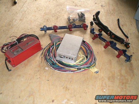 Red MSD ignition box, silver ECU, fuel rail with injectors, and wiring harness