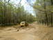 1991 Ford Bronco - A yellow SUV navigates a challenging muddy path through a dense forest.
