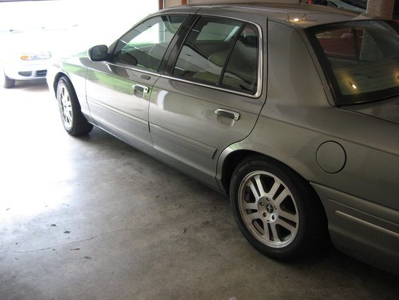 Gray sedan side view, showing rear wheel and fuel door