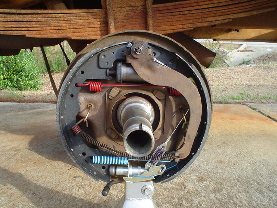 Brake drum assembly with shoes, springs, and cylinder, supported by a stand