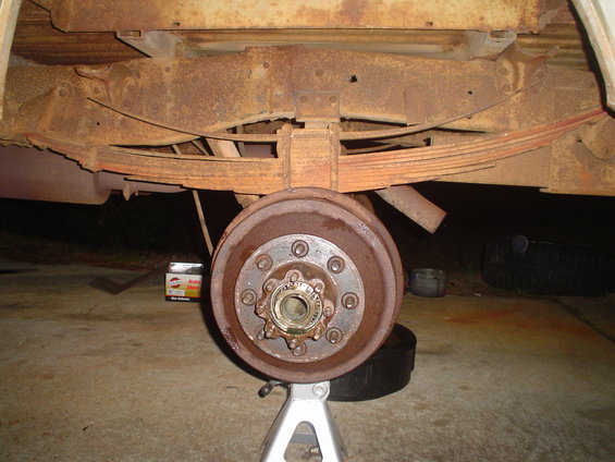 Rear axle assembly of a 1967 Ford F-250, showing rust on the drum brake and leaf springs