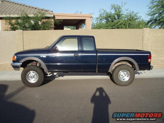 Side view of a dark blue pickup truck parked on a street