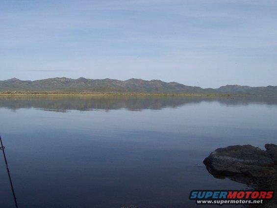 Lake with mountains in background and a fishing rod in foreground