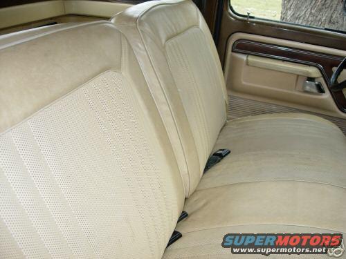 Interior shot of a truck's tan bench seat and door panel. A Supermotors logo is visible