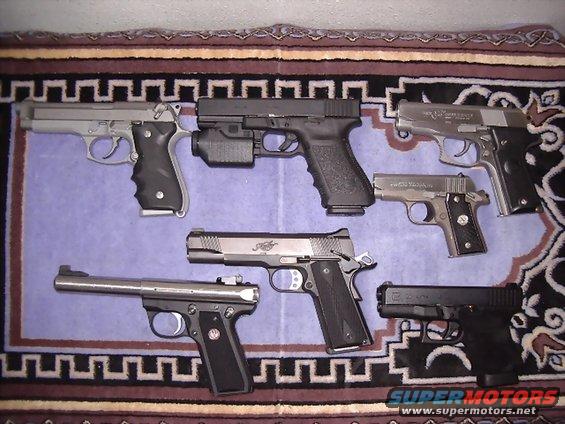 Six handguns arranged on a patterned rug