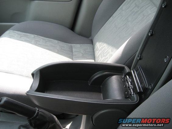 Car interior with open center console armrest and gray patterned seats