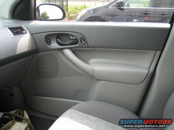 Gray interior door panel with speaker and handle