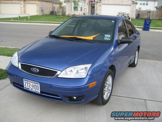 Blue sedan parked on driveway, front 3/4 view