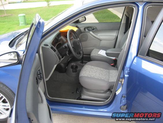 Blue car interior with open doors, showing seats and dashboard