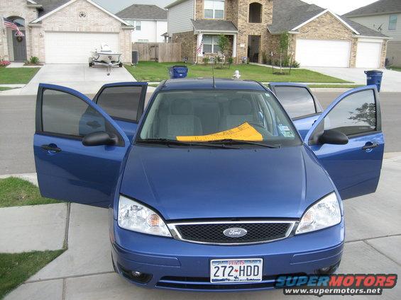 Blue Ford Focus with all doors open, parked in a driveway