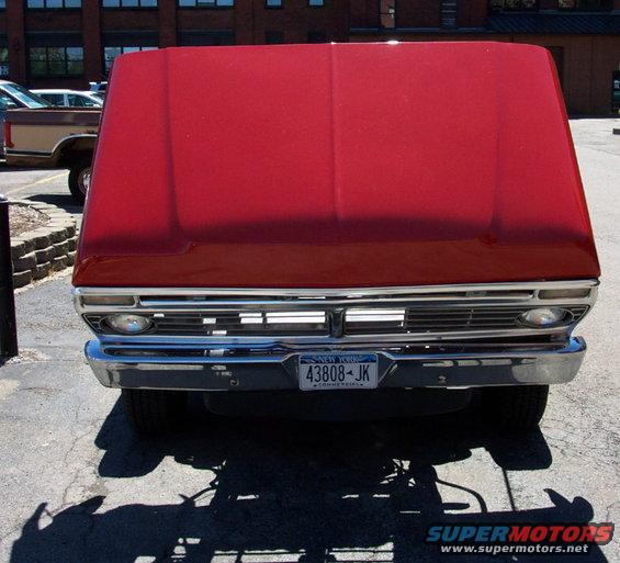 Red truck front end with chrome grille and New York license plate 43808-JK