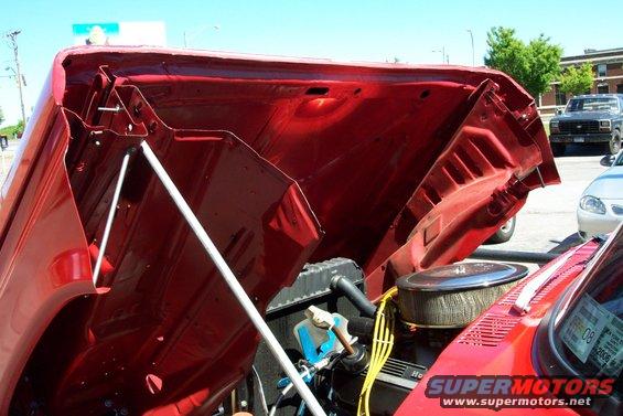 Red engine bay with open hood, showing engine components and air filter
